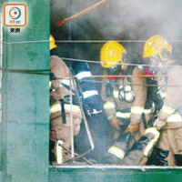 火場倒下<BR>昏迷消防員由同袍抬出火場。（劉子文攝）