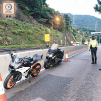 警方在獅子山公路設路障，截查兩輛電單車。