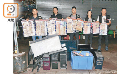 元朗<br>警方展示檢獲的現金及電腦等證物。