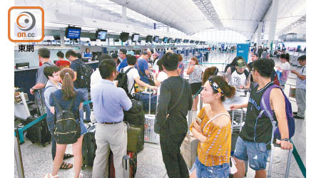 大批旅客趁颱風未到前擠在機場趕搭航機離港。（何天成攝）
