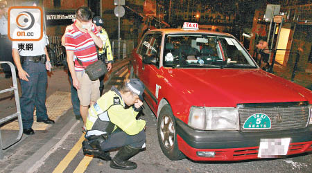 被捕的士司機在場協助警員調查。（葉嘉文攝）