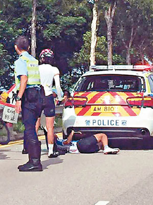 單車與警車碰撞，單車手人仰車翻倒臥地上。（互聯網圖片）