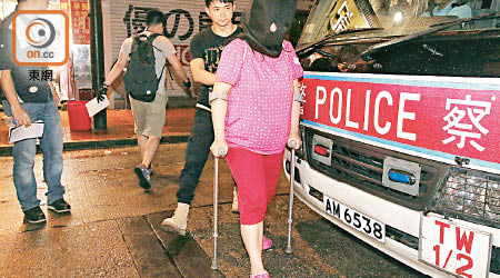 荃灣<br>一名被捕女賭客需用拐杖助行。（沈厚錚攝）