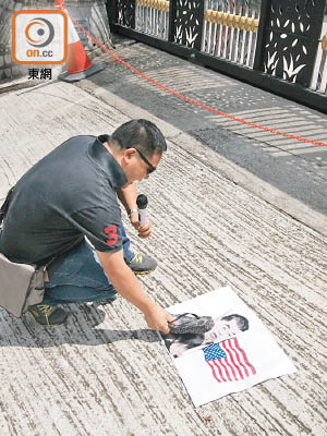 示威者將印有漢奸黎樣貌及美國國旗嘅紙張放在地上打小人。