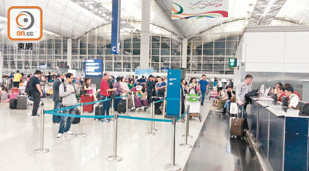 大批乘客在國泰櫃位查詢延飛航班最新情況。（讀者提供）