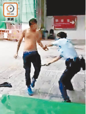 警員用警棍打向男子腳部。