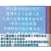 全國人大常委會會議上，介紹了《基本法》第一百零四條的立法含意及法律原則。（電視畫面）