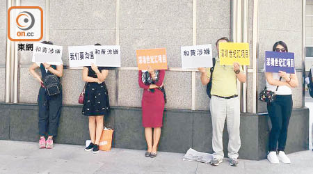 商戶在長江集團中心外舉牌請願。（讀者提供）
