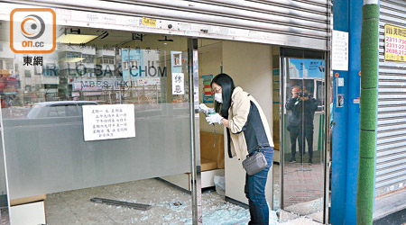 診所玻璃大門損毀，鑑證科人員在現場套取指模。（左錦鴻攝）