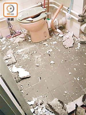 洗手間內有多塊石屎碎片散落一地，坐廁廁板亦毀爛。