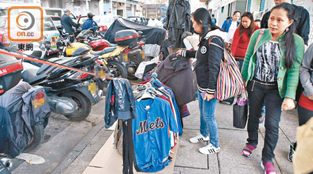 在馬寶道，有小販於行人路販賣二手衫，吸引外傭選購。