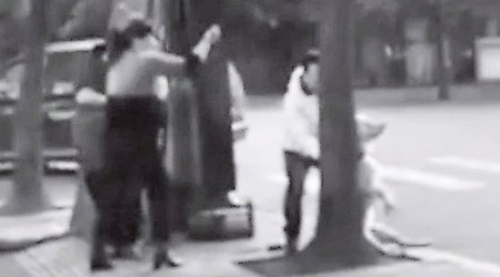綁樹扑頭<br>安徽多名男女當街將狗隻綁在樹上，並用硬物襲擊頭部。（網上黑白圖片）