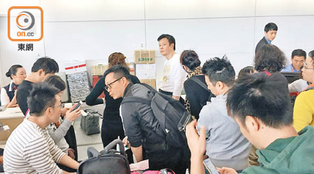 在札幌新千歲機場頓變難民旅客乾着急，只可在航空公司櫃位前等消息。（讀者提供）