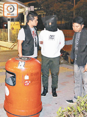 疑犯被押解到棄置衣物的垃圾桶調查。（林耀康攝）