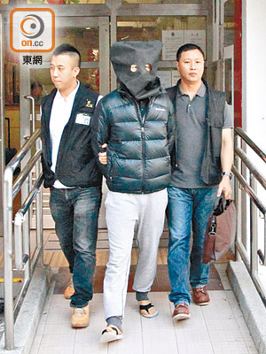 其中一名男疑犯遭押返環翠邨寓所搜證。（張開裕攝）