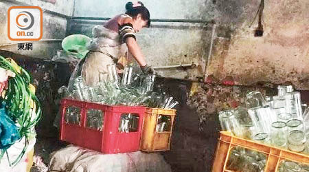在地下工場，一名女子正在清洗盛載冒牌調味料的瓶子。