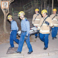 消防員將遺體抬落山。