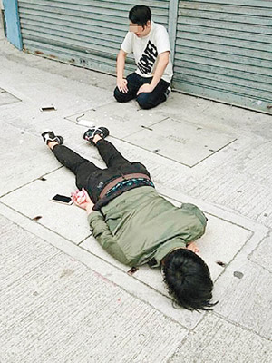 被制服的一名疑犯俯伏在地，另一人則跪地。（互聯網圖片）
