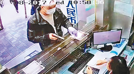 「口罩男」持械圖劫找換店，用槍指向女職員。（資料圖片）