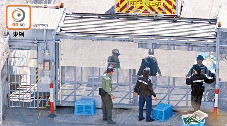 懲教署人員在荔枝角收押所圍網上加設反光板遮擋犯人通道，防止傳媒從外拍攝到犯人情況。（陳章存攝）