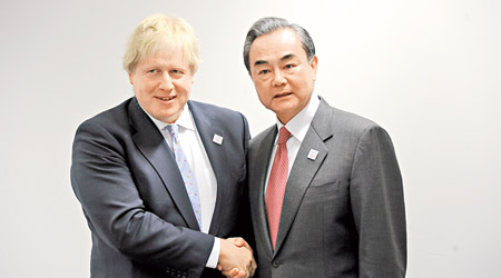 中國外長王毅（右）出席二十國集團外長會時會見英國外相約翰遜（左）。（中新社圖片）