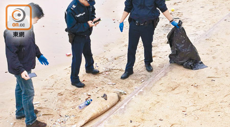 警員在泳灘檢查江豚屍體。（黃子源攝）