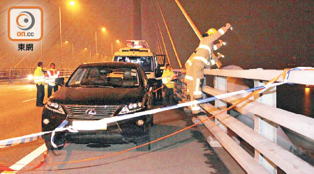 夫婦駕車到橋上跳海，消防員攀上橋邊搜索。（葉嘉文攝）