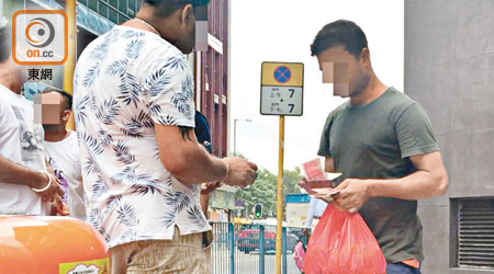 一名南亞裔人士（右）以九百元出售食物券。