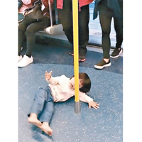 小童在港鐵車廂圍着扶手杆四圍爬。（fb「強國瘋情畫」影片截圖）