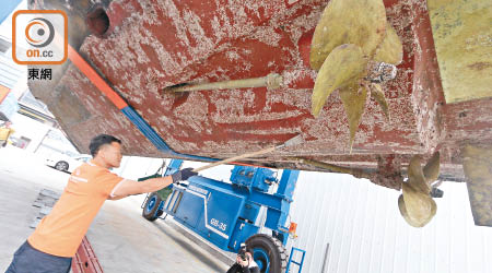 工人在每年維修清理船底的微生物及蠔宿時，會將含重金屬的物質沖落海。（黃知樂攝）