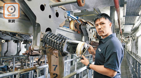 吳銘峰用工具量度車轆直徑，以確定有否磨損。