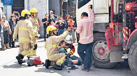 單車男倒臥車頭位置，消防協助拯救。（互聯網圖片）