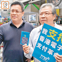 （左起）：江慶恩、廖社青<br>市民下載手機應用程式後，輕掃二維碼即完成付款。