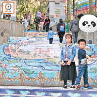 香港公園內的樓梯，貼上十八世紀，銅胎畫琺瑯開光「三羊啟泰」、「荷花鴛鴦」紋暖手爐的圖案。（吳康琪攝）