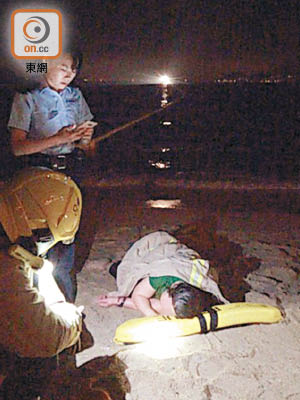 獲救婦人躺在沙灘痛哭。