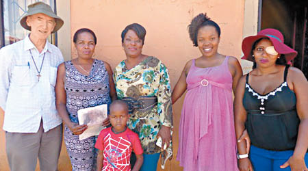 女被告的家人（左二至左五）應「廟街神父」胡頌恆（左）邀請，接受南非電視台訪問，令招攬者成功被捕。