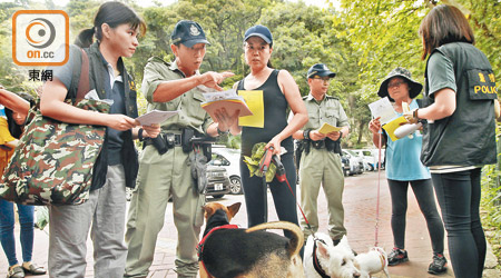 警方於寶雲道一帶派發宣傳單張及張貼海報，呼籲如發現毒餌或可疑人士，就向警方或愛護動物協會舉報。（黃仲民攝）