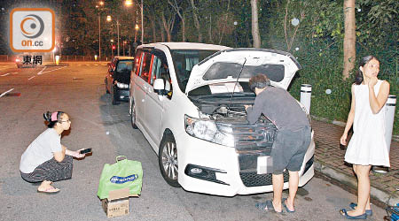 車主友人打開車頭冚，貓咪趁機跳出竄入草叢消失，圖左及右為兩名愛心少女。