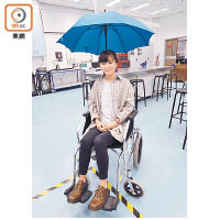 李諾瑜設計出伸縮雨傘支架連輪椅，方便輪椅使用者開傘擋風雨。（羅錦鴻攝）