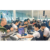 深圳機場多個航班取消，乘客到櫃枱前查詢。（互聯網圖片）