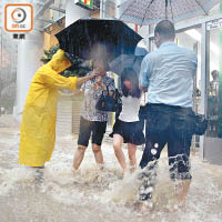 堅尼地城<br>堅尼地城觀龍樓門口水浸，市民狼狽涉水。