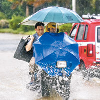 惠州多條馬路被水淹浸，車輛要涉水而過。（中新社圖片）