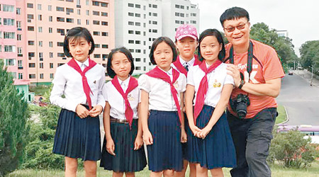 馮煒光（右一）同當地一批女學生拍照留念。（互聯網圖片）