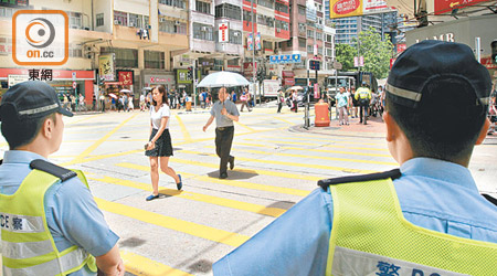 警方昨日上午在佐敦道、上海街交界執法，票控衝紅燈的市民。（張開裕攝）