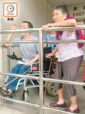 女被告羅龍芽（右）由坐輪椅的兒子（左）陪同到庭應訊。