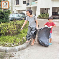 「進進」跟隨母親到屋苑執垃圾。（林珮淇攝）