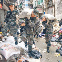 十月初五街<br>道路不通，官兵們背負所檢拾的垃圾袋步出街頭。（互聯網圖片）