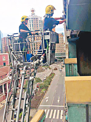 南灣大馬路<br>消防人員架起雲梯，清除樓宇易墮物品。（互聯網圖片）