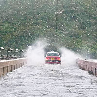 大潭水塘主壩水浸，車輛駛經如過「紅海」。（互聯網圖片）