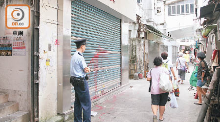 發祥街店舖捲閘被潑紅油，警方在場調查。（曾志恆攝）